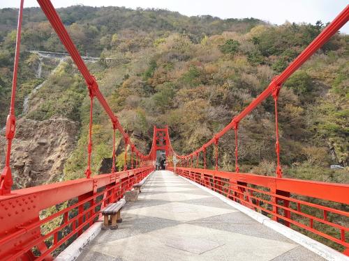 a red bridge with a person on it at 拉拉山周家渡假旅館020民宿 in Hualing