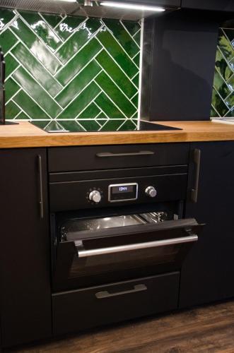 a kitchen with a black counter top with a oven at Dorpsplein Appartement in Zandvoort