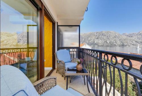 a balcony with chairs and a view of the water at Apartments Bonaca in Kotor