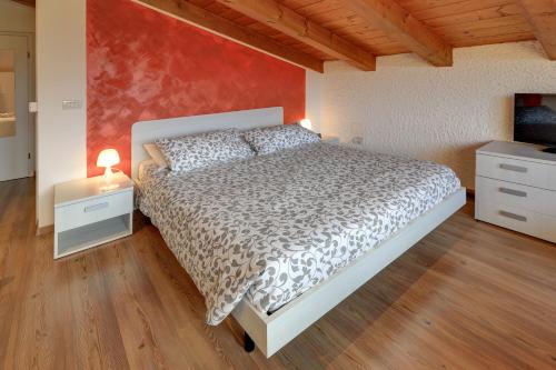 a bedroom with a bed and a red wall at Dal Rosso in San Floriano del Cóllio