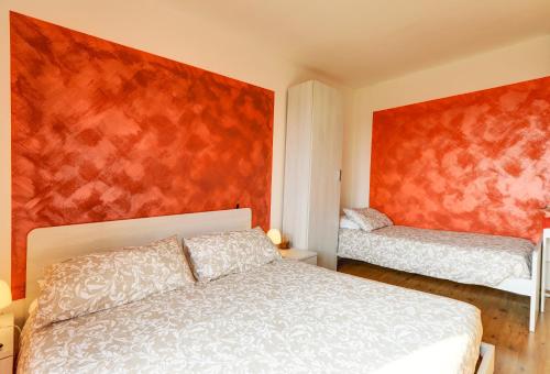 a bedroom with a bed and a red wall at Dal Rosso in San Floriano del Cóllio