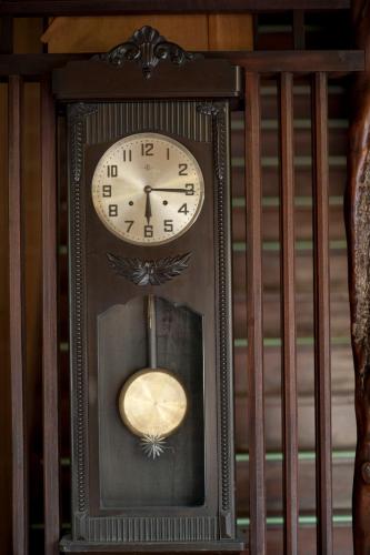 a grandfather clock with a clockigunigunigunigunigunigun at Hinode Ryokan in Ise