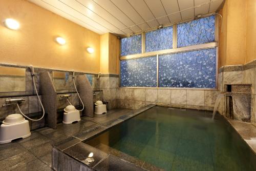 un bagno con una grande piscina d'acqua di Station Hotel AU a Tsu
