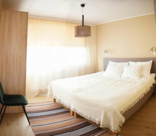 1 dormitorio con 1 cama blanca grande y ventana en Liivaoja Apartment en Kärdla