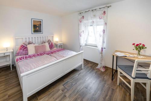 Schlafzimmer mit einem Bett, einem Schreibtisch und einem Fenster in der Unterkunft Marinas Ferienwohnungen in Vordernberg