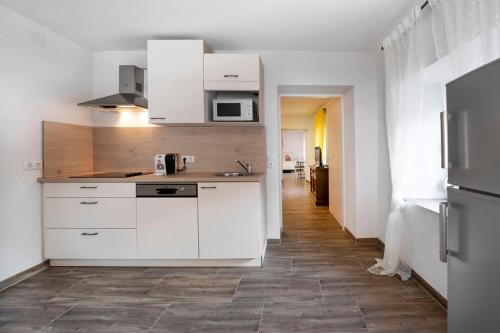 eine Küche mit weißen Schränken und Fliesenboden in der Unterkunft Marinas Ferienwohnungen in Vordernberg