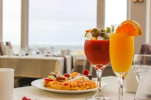 a table with a plate of food and two glasses of juice at Water's Edge Resort & Spa in Westbrook