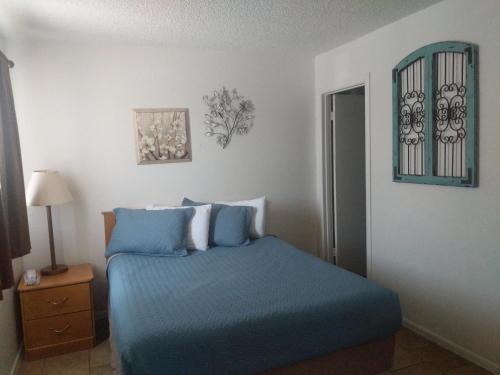 a bedroom with a blue bed and a window at Little Daisy Motel in Cottonwood