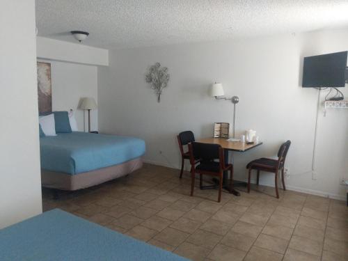 a hotel room with a bed and a table and chairs at Little Daisy Motel in Cottonwood