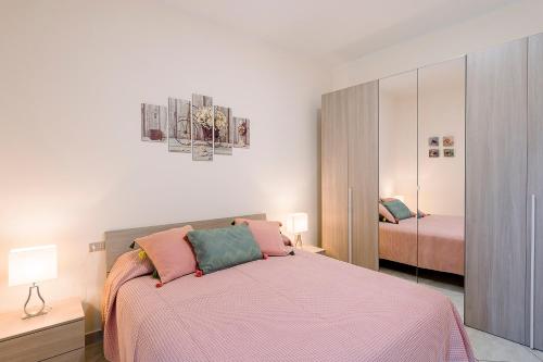 a bedroom with a bed with a pink blanket at Villa san Lorenzo rooms in Scala