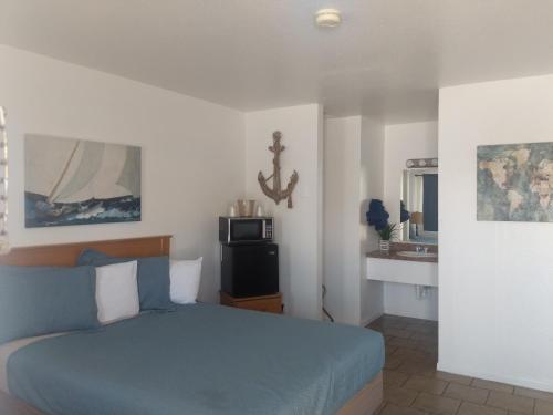 a bedroom with a blue bed and a sink at Little Daisy Motel in Cottonwood