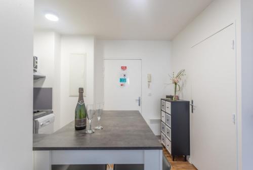 - une cuisine avec un comptoir et 2 verres à vin dans l'établissement Appartement Confort Paris, à Montévrain