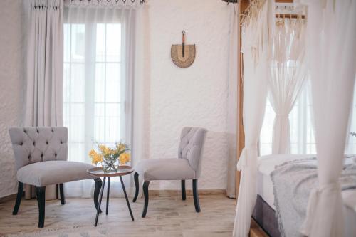 a bedroom with a bed and two chairs and a table at Alachi Hotel in Alacati
