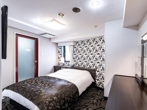 a bedroom with a bed with a black and white patterned wall at APA Hotel Sapporo Housuisusukino Ekimae in Sapporo