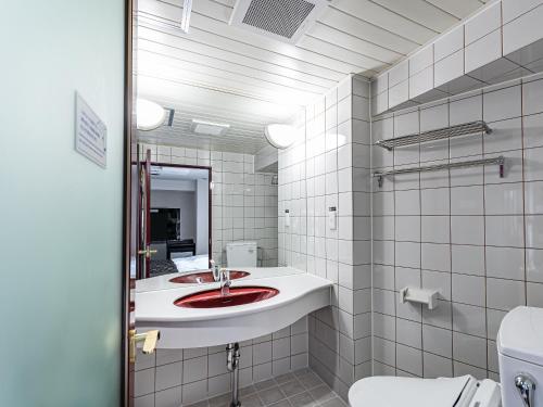 een badkamer met een wastafel, een toilet en een spiegel bij APA Hotel Sapporo Housuisusukino Ekimae in Sapporo