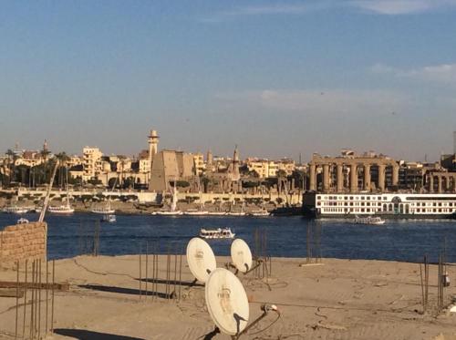 a group of satellite dishes sitting in front of a body of water at The Brown House in Luxor