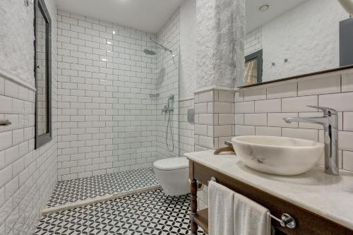 a bathroom with a sink and a toilet at Alachi Hotel in Alacati