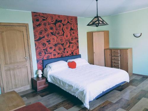 a bedroom with a bed with a red pillow on it at Irene apartments in Druskininkai