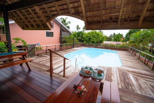 uma piscina num deque de madeira com uma casa em BORA BORA HOLIDAY'S LODGE em Bora Bora