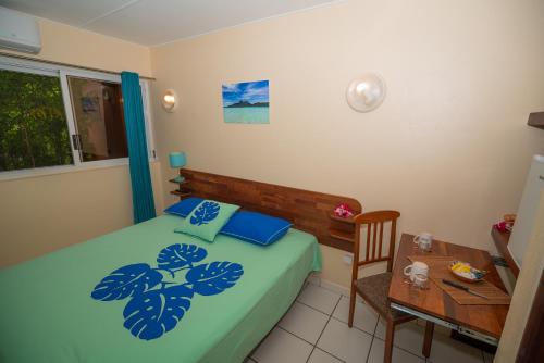 a bedroom with a bed and a table and a desk at BORA BORA HOLIDAY'S LODGE in Bora Bora