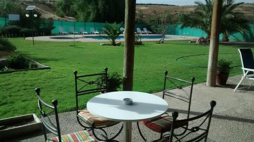 a white table and chairs with a table and a field at Cabañas Stommeln in Ovalle