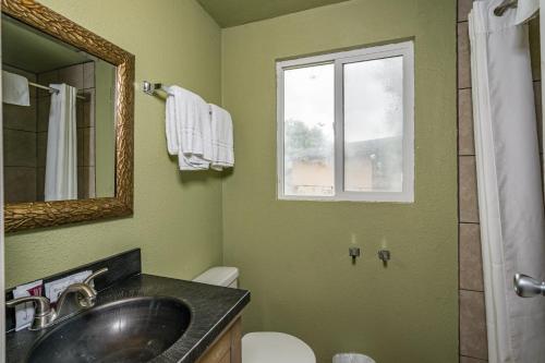 a bathroom with a sink and a toilet and a window at Mountain Trail Lodge and Vacation Rentals in Oakhurst