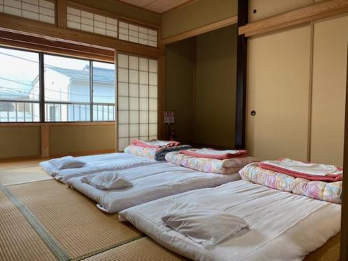 una fila di materassi allineati in una stanza di Yasunoya #HH2x a Toyama