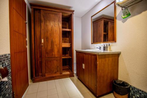 ein Badezimmer mit einem Waschbecken und einem Holzschrank in der Unterkunft Sisin Ubud View in Ubud