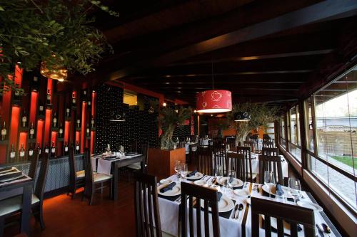 un restaurante con mesas y sillas y una lámpara de araña roja en Posada Real La Yensula en El Puente
