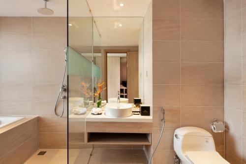 a bathroom with a shower and a toilet and a sink at DQua Hotel in Nha Trang