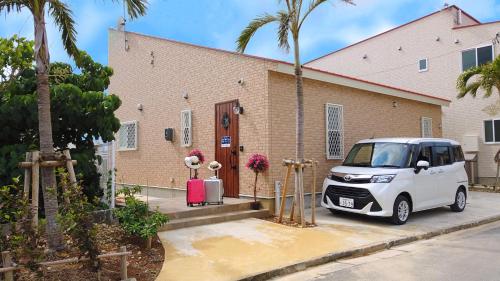 a white car parked in front of a building at Ecot Shimozato 1 in Miyako Island