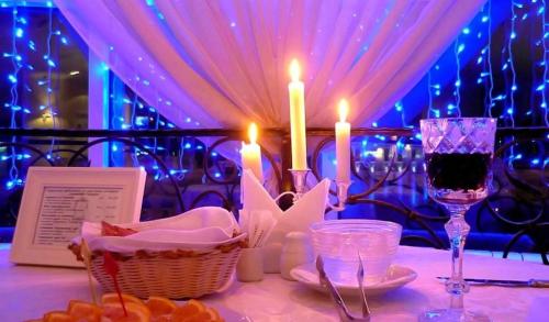 a table with candles and a basket of food and wine at Mini-Hotel Ilma in Petrozavodsk
