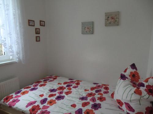 a bedroom with a bed with a floral comforter at Ferienwohnung Rosenflair in Schönebeck