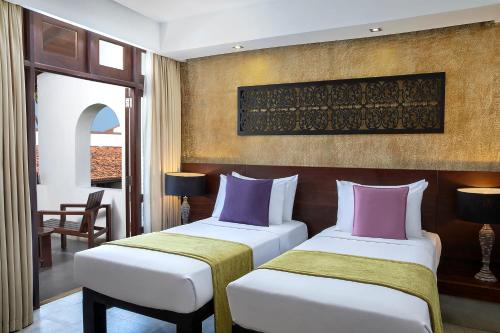 a hotel room with two beds in a room at Avani Kalutara Resort in Kalutara