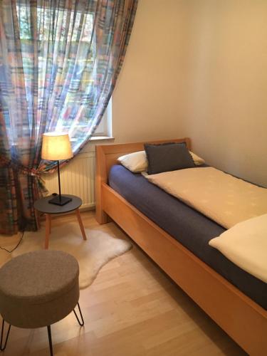um quarto com uma cama, um candeeiro e uma cadeira em Appartement 29/1 em Schwäbisch Hall