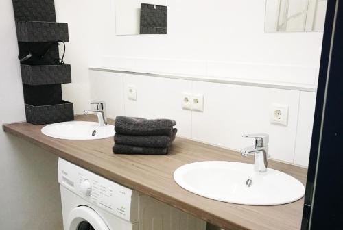a bathroom with two sinks and a washing machine at Work & Stay in Emmerich in Emmerich