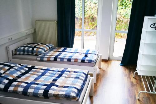 2 camas en una habitación con ventana en Work & Stay in Emmerich, en Emmerich