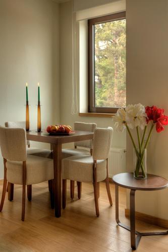 a dining room table with chairs and a vase of flowers at Euphoria Club Hotel in Borovets