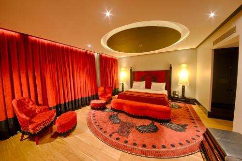 a bedroom with a large bed and red curtains at Selectum Luxury Resort Belek in Belek