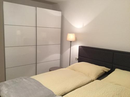 1 dormitorio con 2 camas y lámpara en Appartement 29/1 en Schwäbisch Hall