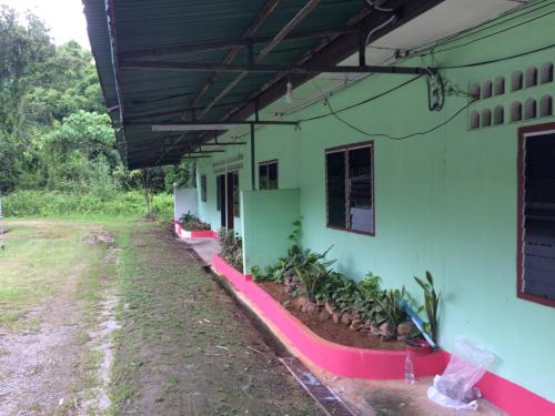 a side view of a building with plants in a yard at AP Hotel in Ban Nam Chan Tai