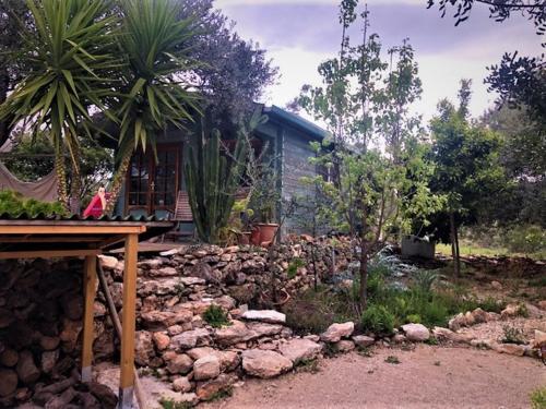 a house with a pile of rocks in front of a yard at Finca Florecer in Tivenys