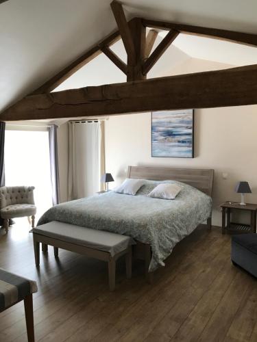 1 dormitorio con 1 cama y suelo de madera en La Boisnière, en Mouilleron-en-Pareds