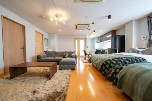 a bedroom with two beds and a living room with a couch at HOTEL er. in Kobe