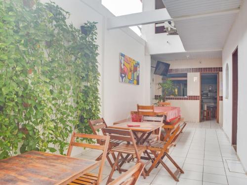 a patio with tables and chairs and a green wall at Pousada Pepone - Fortaleza Centro in Fortaleza