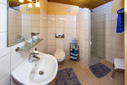 a bathroom with a sink and a shower and a toilet at Haus Bergblick in Oy-Mittelberg