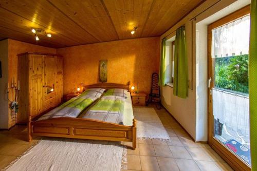 a bedroom with a bed and a large window at Haus Bergblick in Oy-Mittelberg