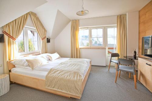 a bedroom with a bed and a desk and windows at Beskid Ski Villa in Wisła