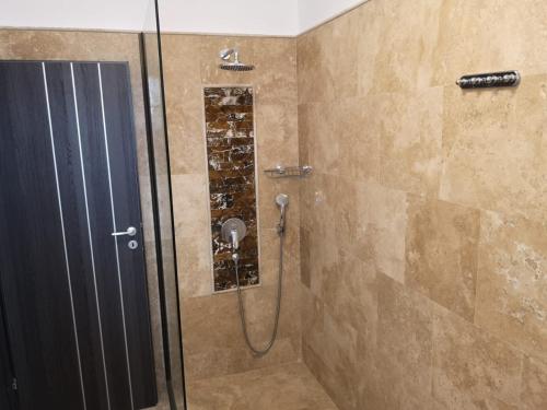 a shower with a glass door in a bathroom at VELVET RESIDENCE in Mamaia Sat/Năvodari
