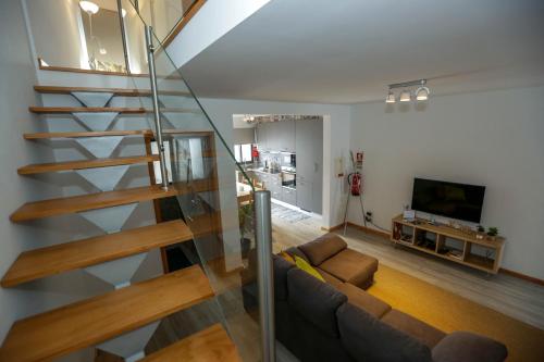 a living room with a couch and a staircase at Casa do Califórnia in Ribeira Grande